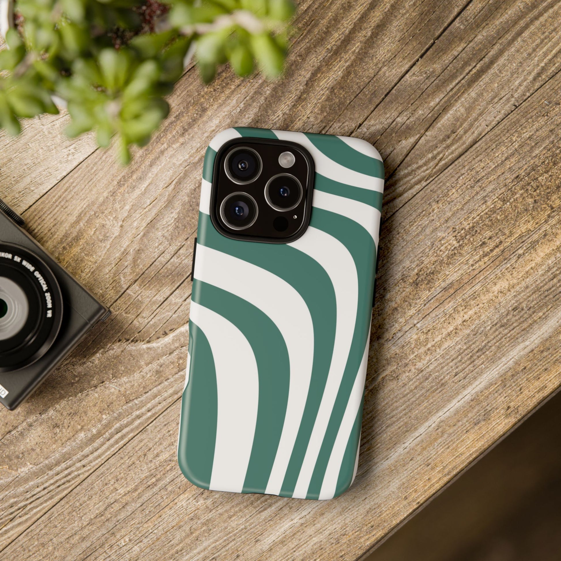 Aesthetic iPhone case with green and white retro wave design placed on wooden table – stylish protective phone cover mockup