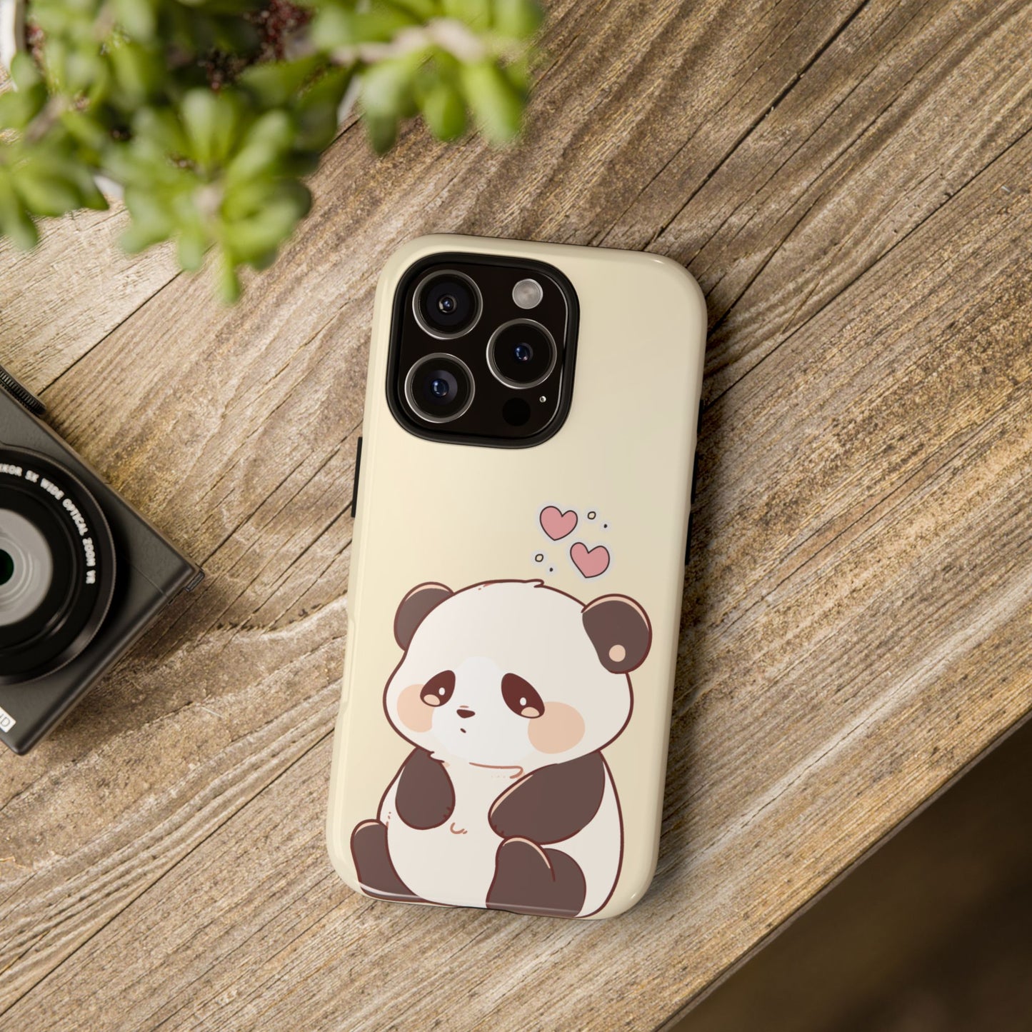 Lifestyle image of kawaii panda iPhone case on wood background – cute cartoon bear design with pink hearts for soft aesthetic and gift shoppers